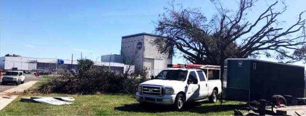 Tree Man Inc. truck and chipper trailer beside a storm damaged tree during tree removal in Kenner, LA
