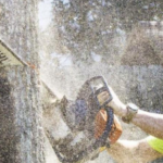 Tree Man Inc. climber making a cut with a chainsaw during tree trimming services in Harahan, LA